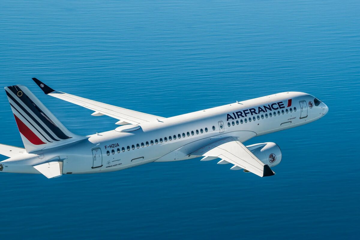 Air France airplane flying above the ocean with the Air France logo on the fuselage.
