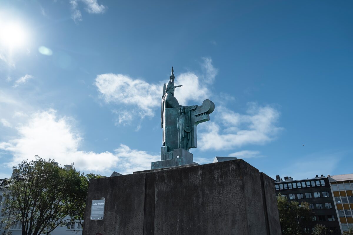 Ingólfur Arnarson statue on Arnarhóll hill under a blue sky in Reykjavik.