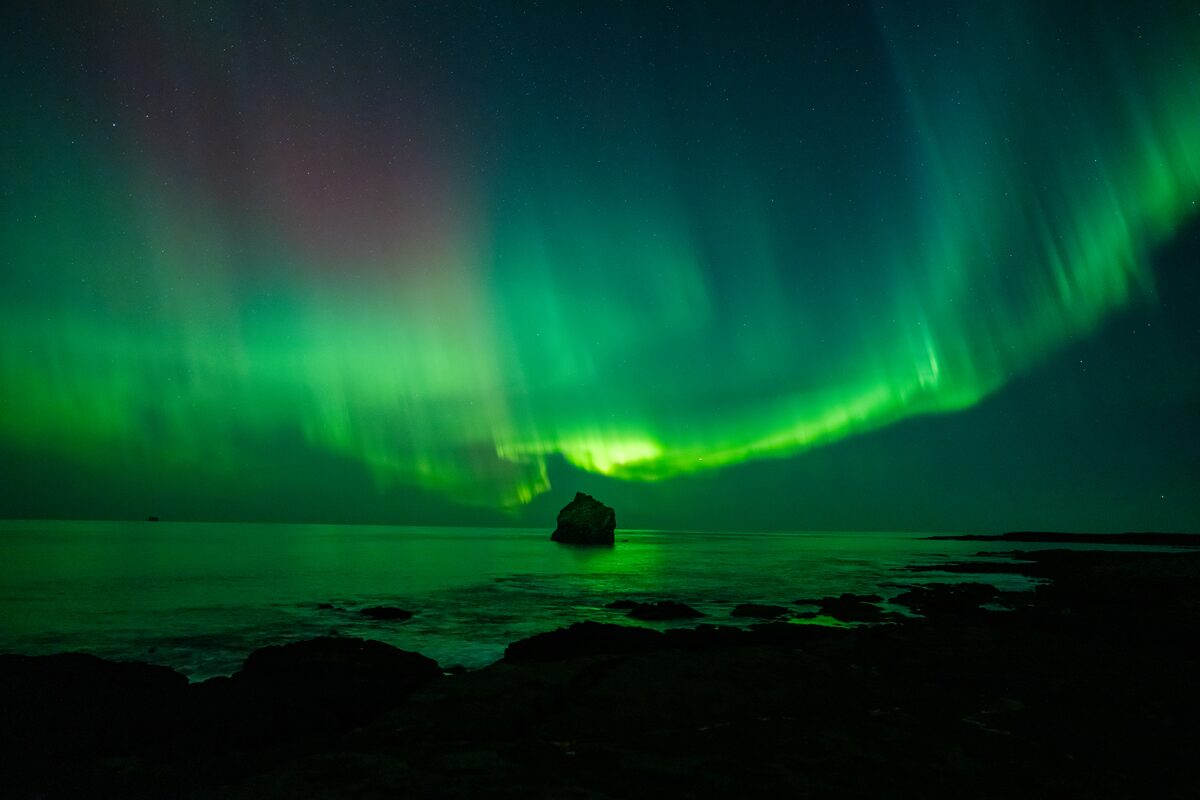 Green Northern Lights above the South Coast in South Iceland at night.