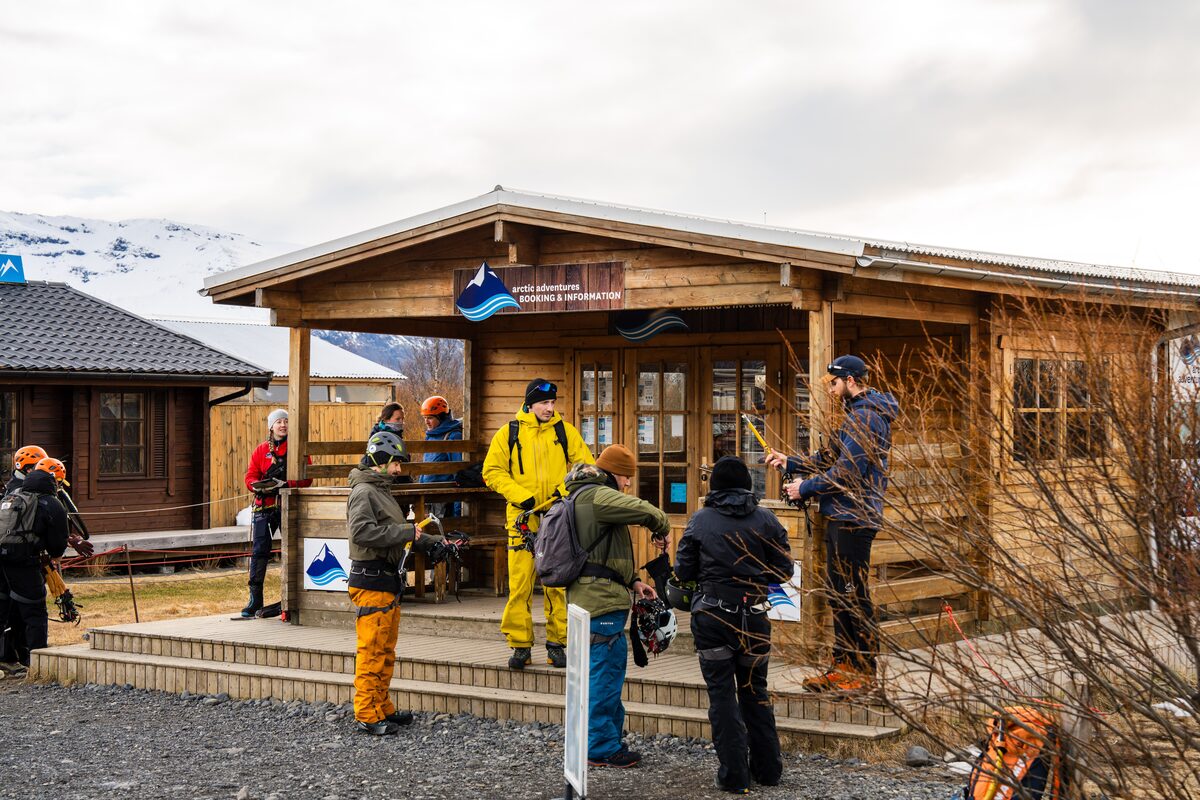 Guests with gear in front of the Arctic Adventures Booking & Information hut