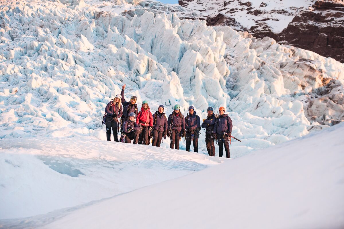 Happy group with jagged glacier feature behind them in Iceland
