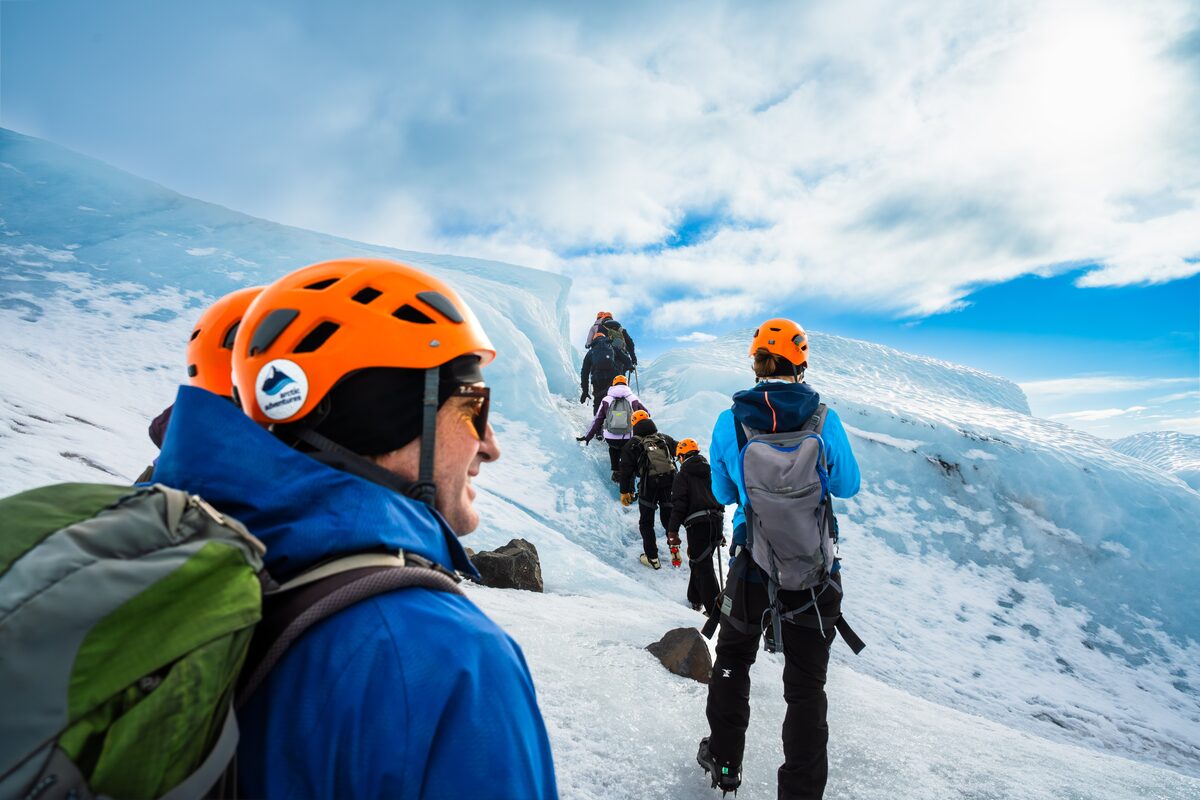 Happy guest with group walking through blue ice in front of him