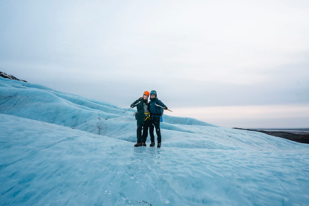Two People Holding Pickaxes On Ice in Iceland