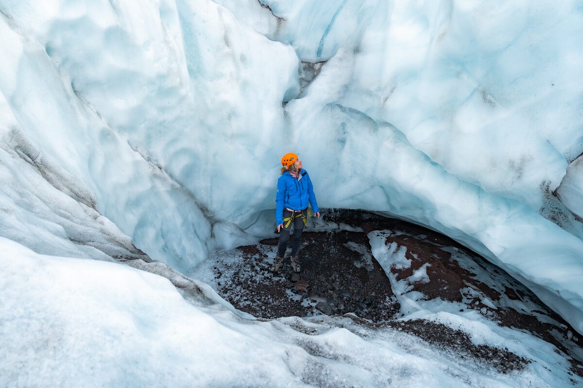 Woman in orange helmet surrounded by blue and white snow