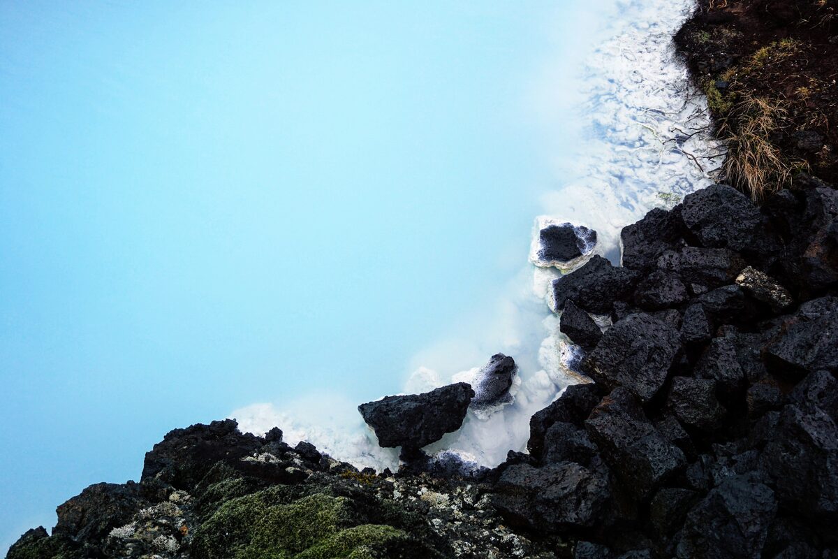 Milky blue water and black lava rocks at the Blue Lagoon in Iceland. 