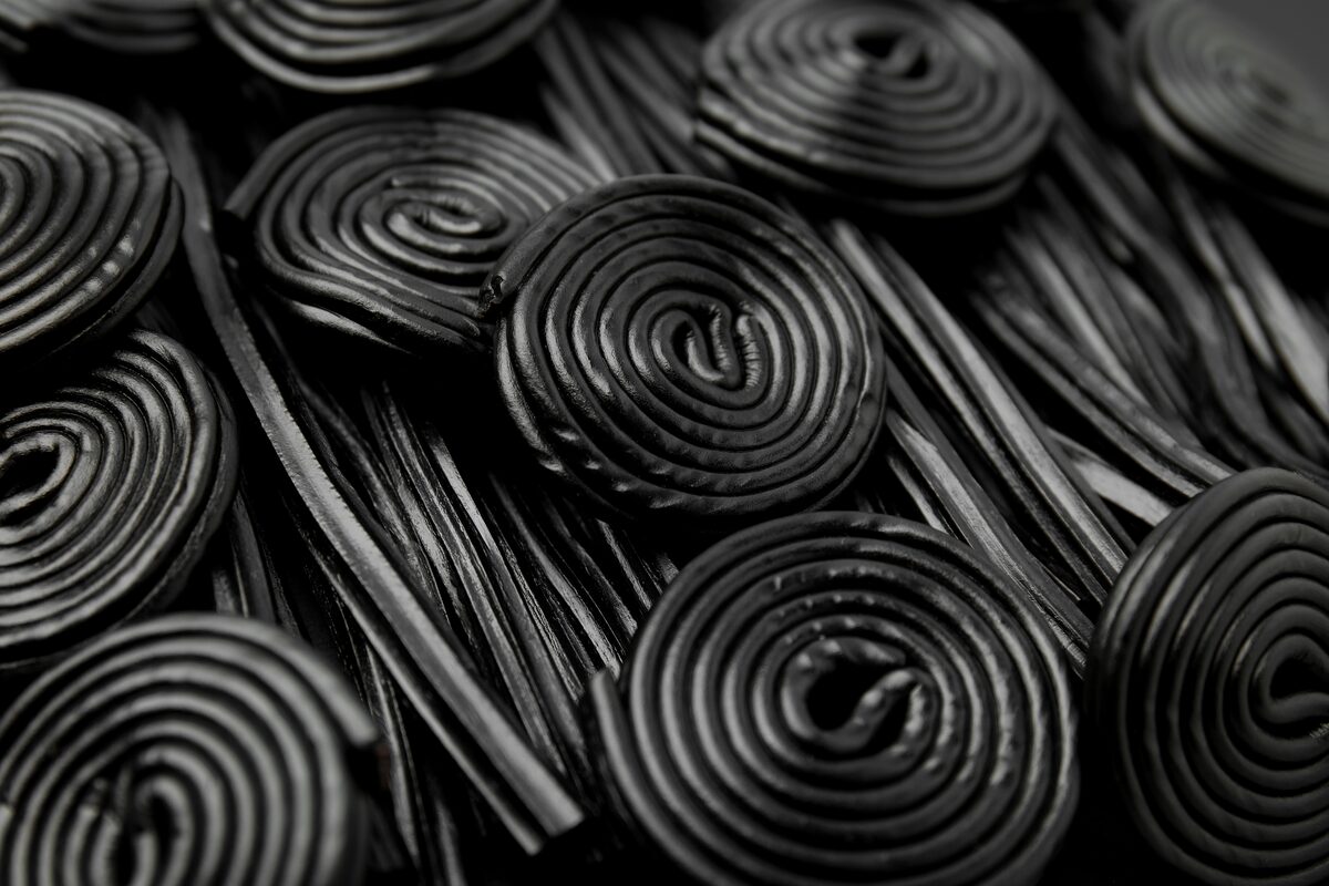 Black licorice spirals and laces arranged closely together. 