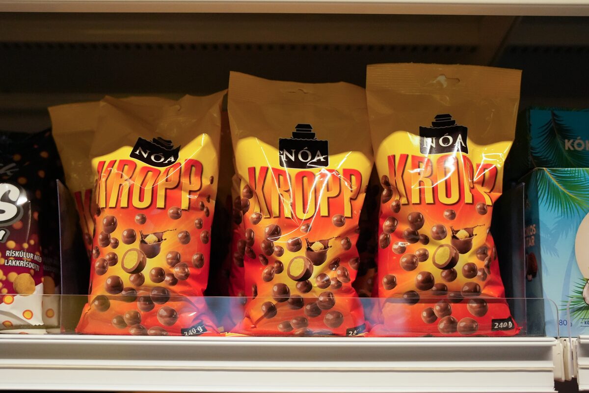 Nóa Kropp chocolate-coated corn puff bags on an Icelandic store shelf next to other local snacks.