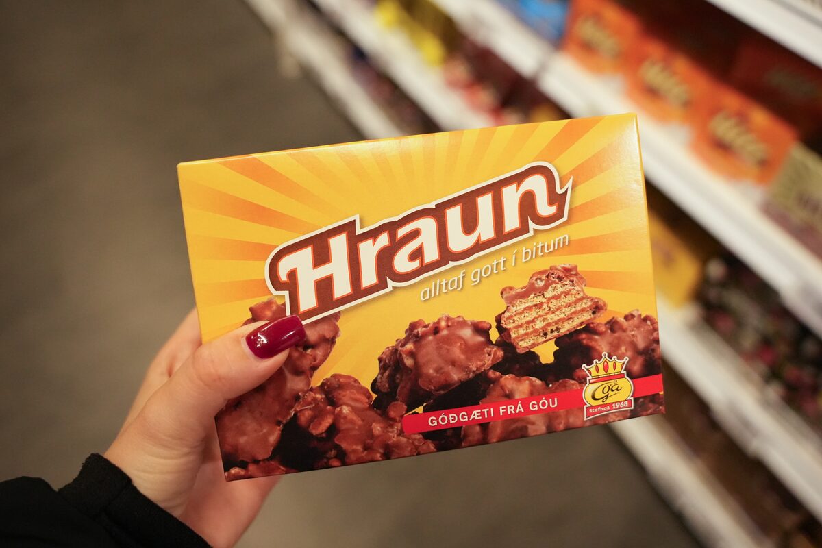 Hand holding a yellow box of Hraunbitar chocolate wafer bites by Góa in a store.