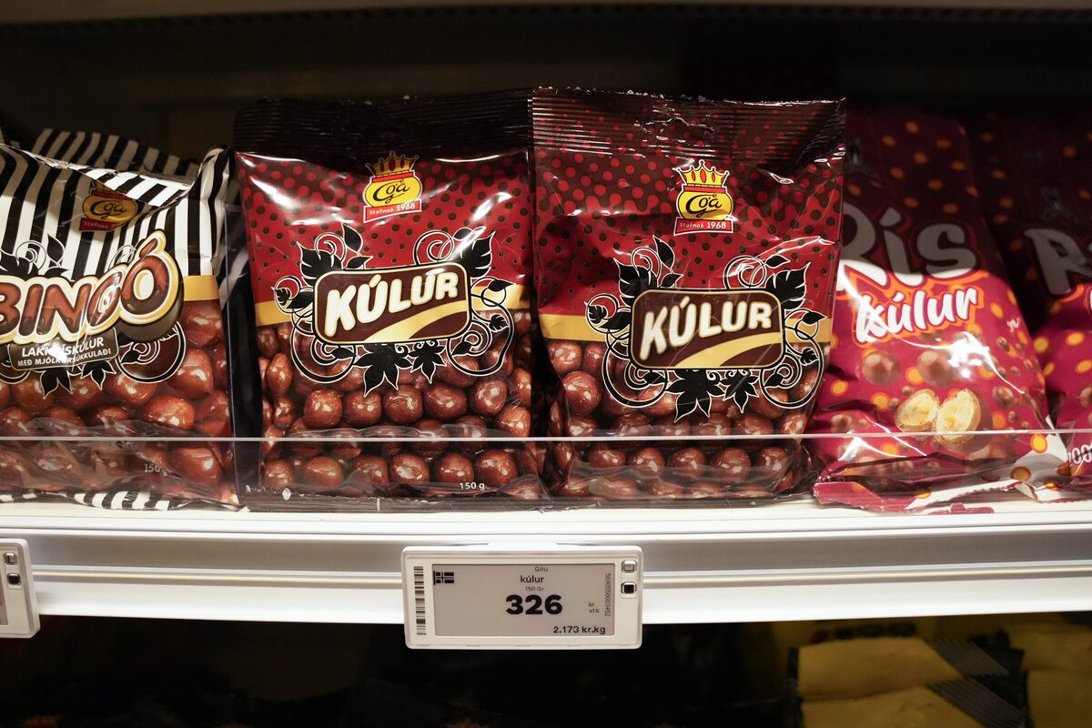 Bags of Kúlur chocolate-coated toffees on a store shelf with price tags.