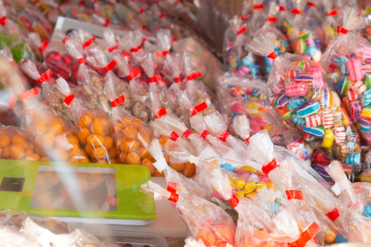 Assorted colorful candy in clear bags displayed at a market stall.