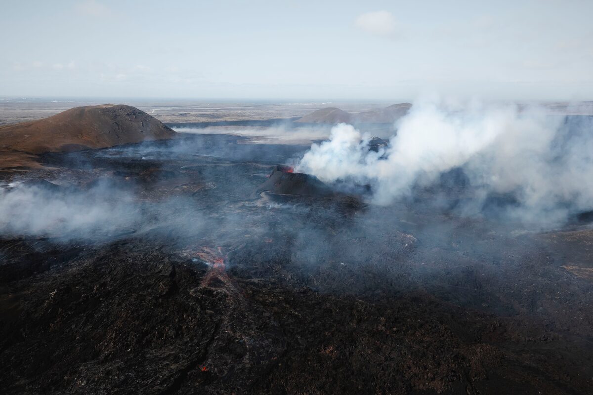 Aerial view of fresh black lava and steam rising from the Sundhnúkagígar eruption on Iceland's Reykjanes Peninsula.