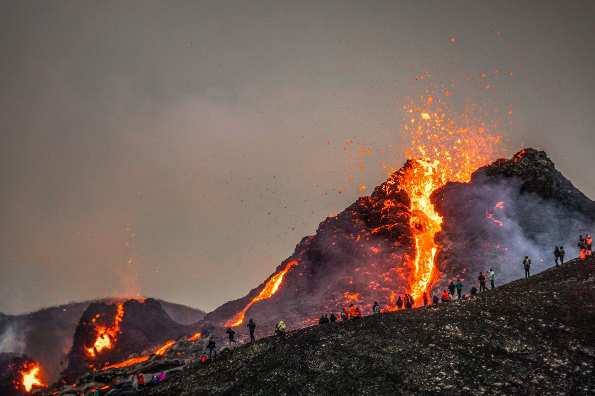 Crowds of people watching lava fountains erupt from Fagradalsfjall volcano in Iceland, March 2021.