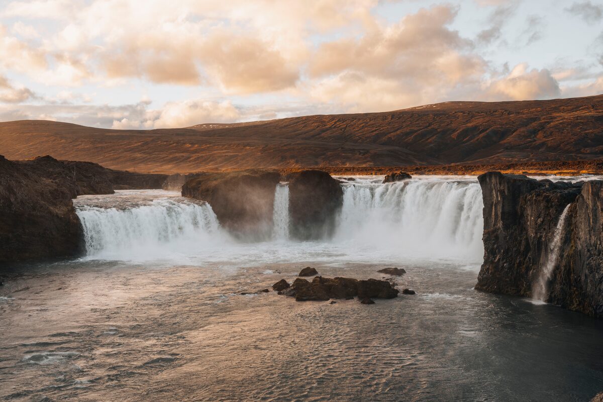 Goðafoss waterfall curving in a horseshoe arc at sunrise on the Skjálfandafljót river.