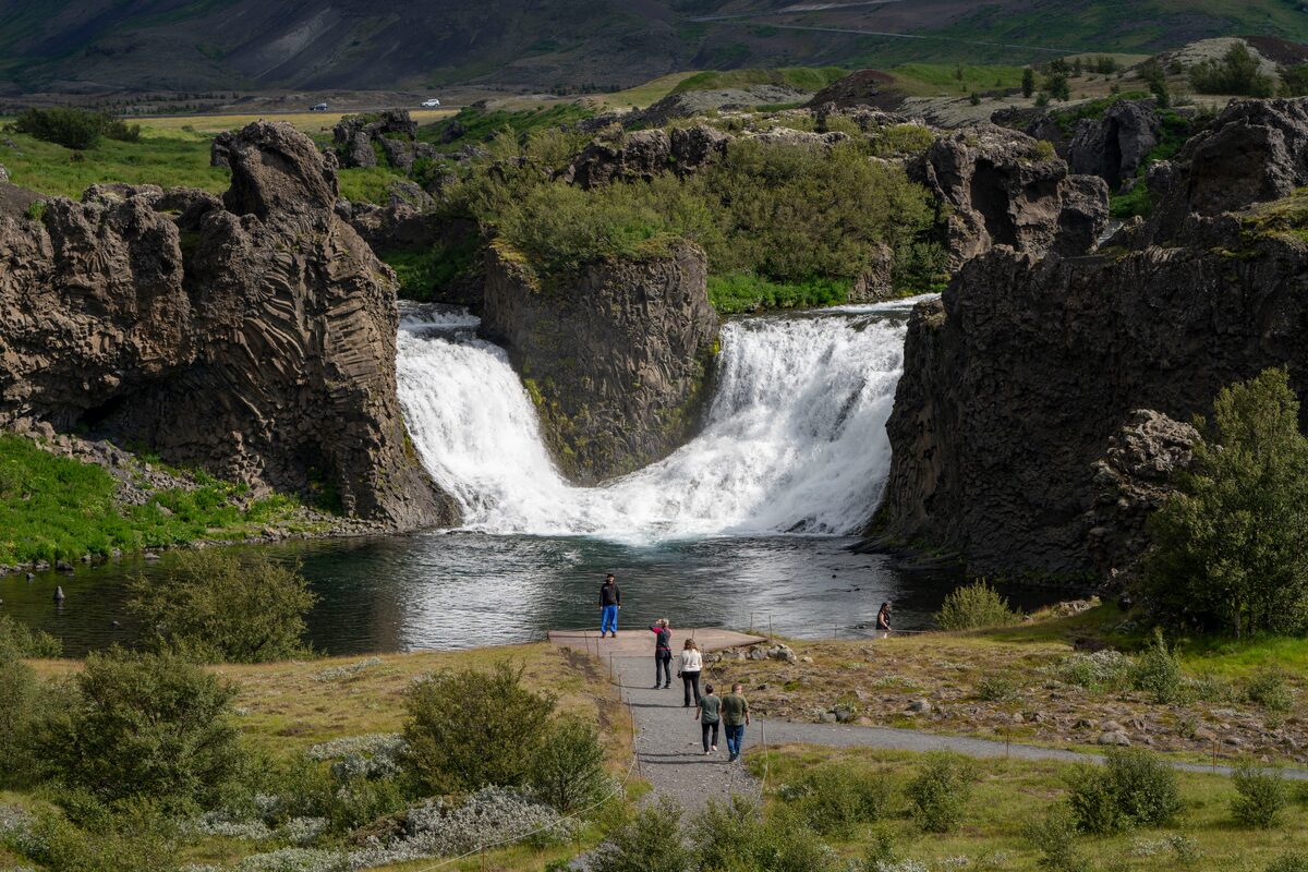 Hjálparfoss double waterfall flowing between basalt columns into a pool in South Iceland.
