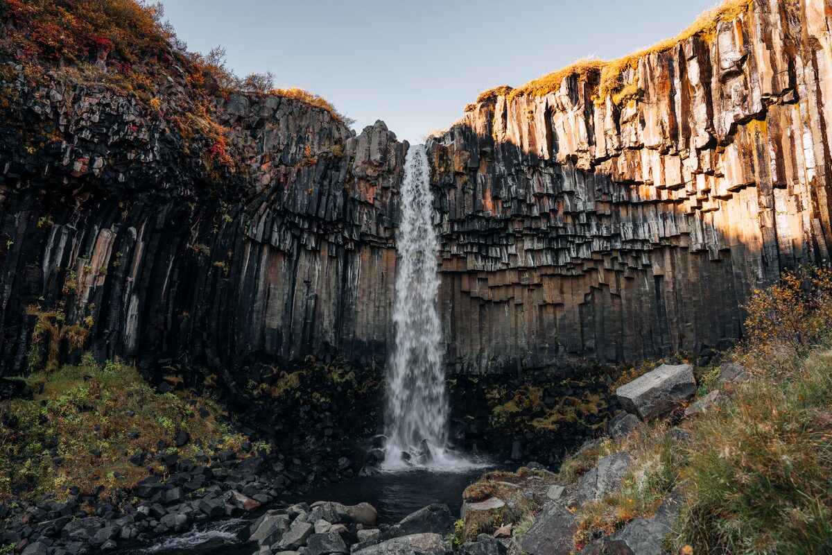 Svartifoss waterfall falling over dark hexagonal basalt columns in Skaftafell, Iceland.