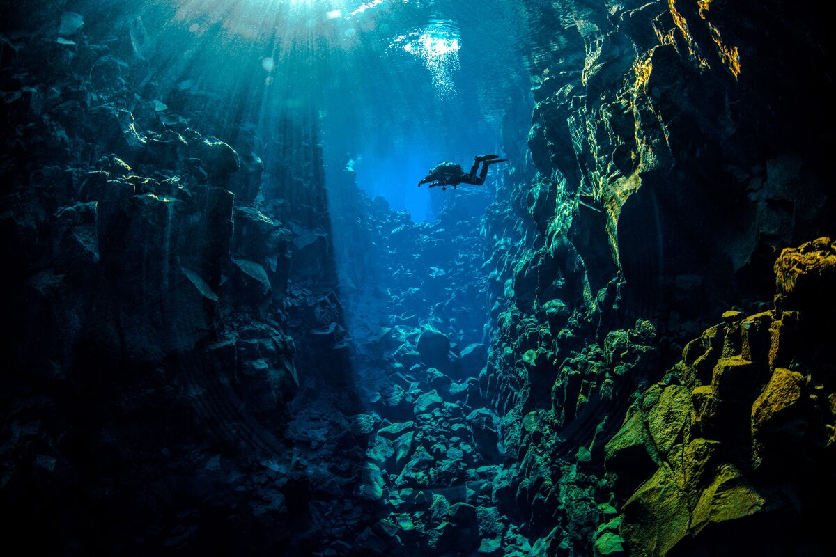 Diver Between Silfra Rocky Walls in Iceland
