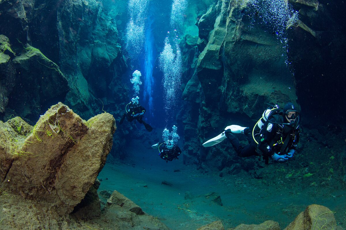 Three People Diving In Silfra in Iceland