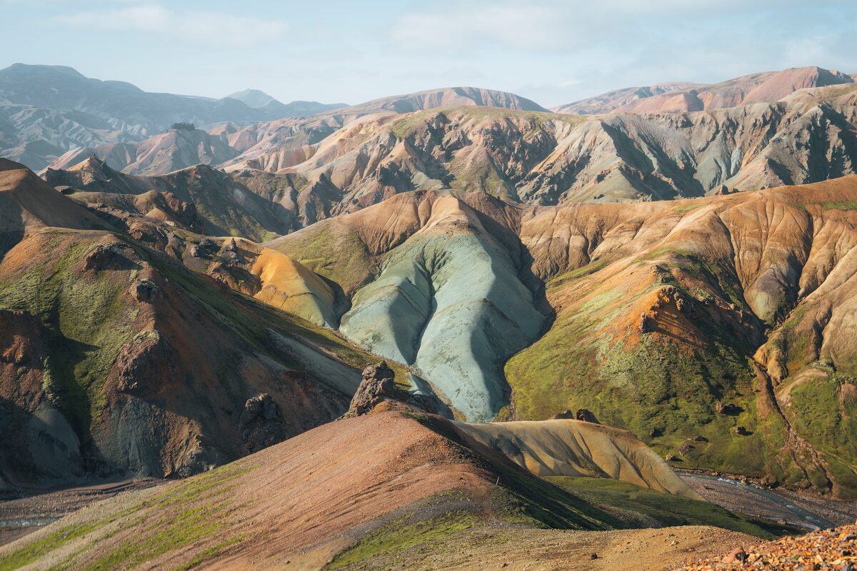 Grænihryggur's blue-green rhyolite spine surrounded by red and orange slopes in Landmannalaugar.