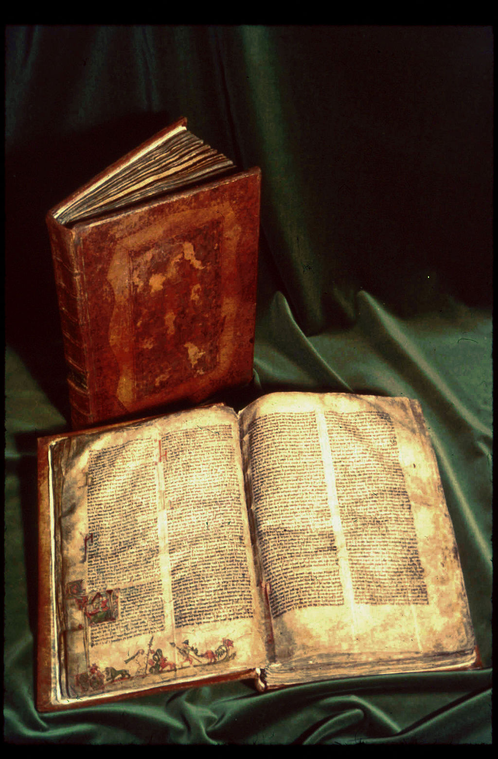 The Codex Regius open on vellum pages beside a closed manuscript.