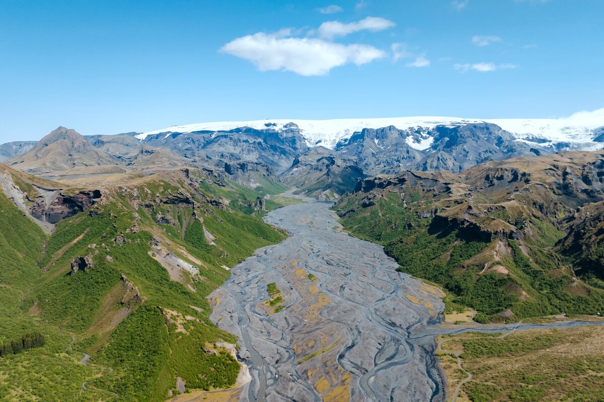 Braided river running through Þórsmörk valley with a glacier on the mountain ridge beyond.