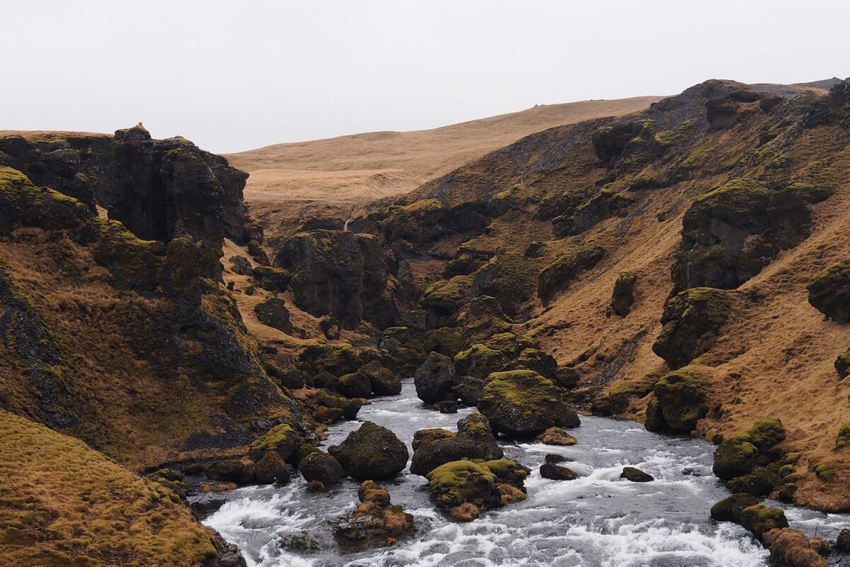 The Skógá river running through a canyon with mossy basalt walls in South Iceland.