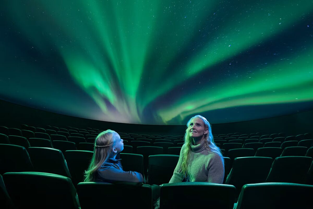 Mother And Daughter Looking At Northern Lights At Perlan in Iceland