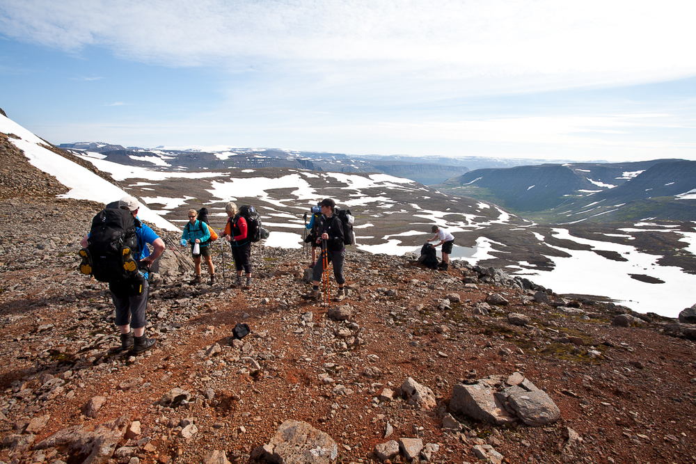 Hiker Group On A Hill With Snow Behind Them in Iceland