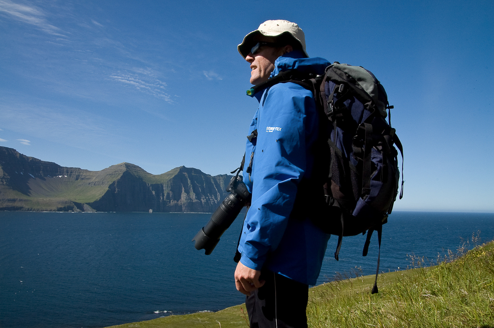 Hiker With A Camera Standing Near Water At Hornstrandir Nature Reserve in Iceland