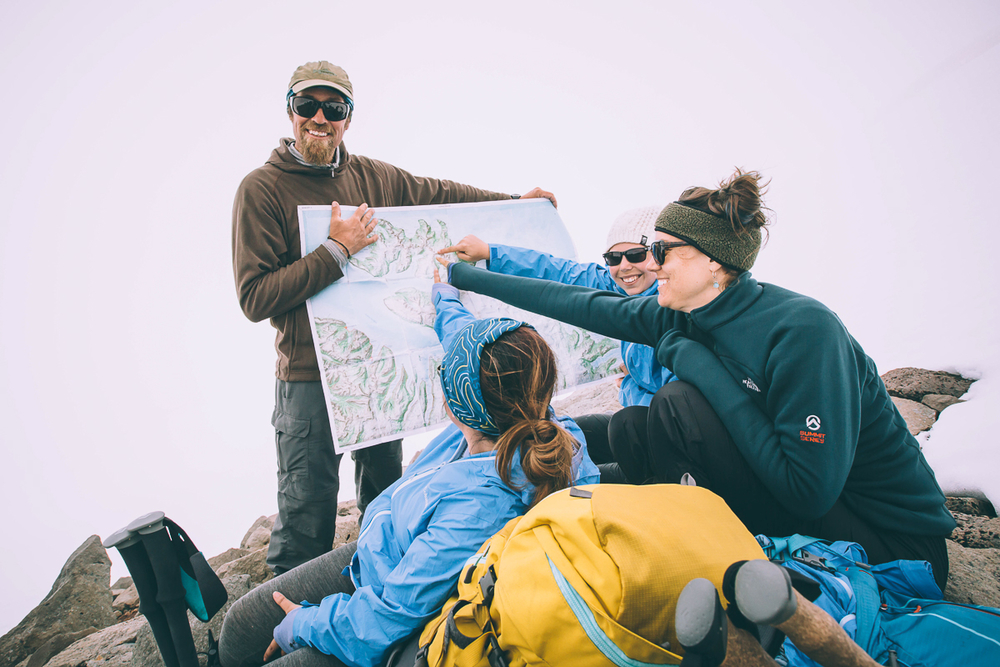 Hikers Looking And Pointing At A Map in Iceland
