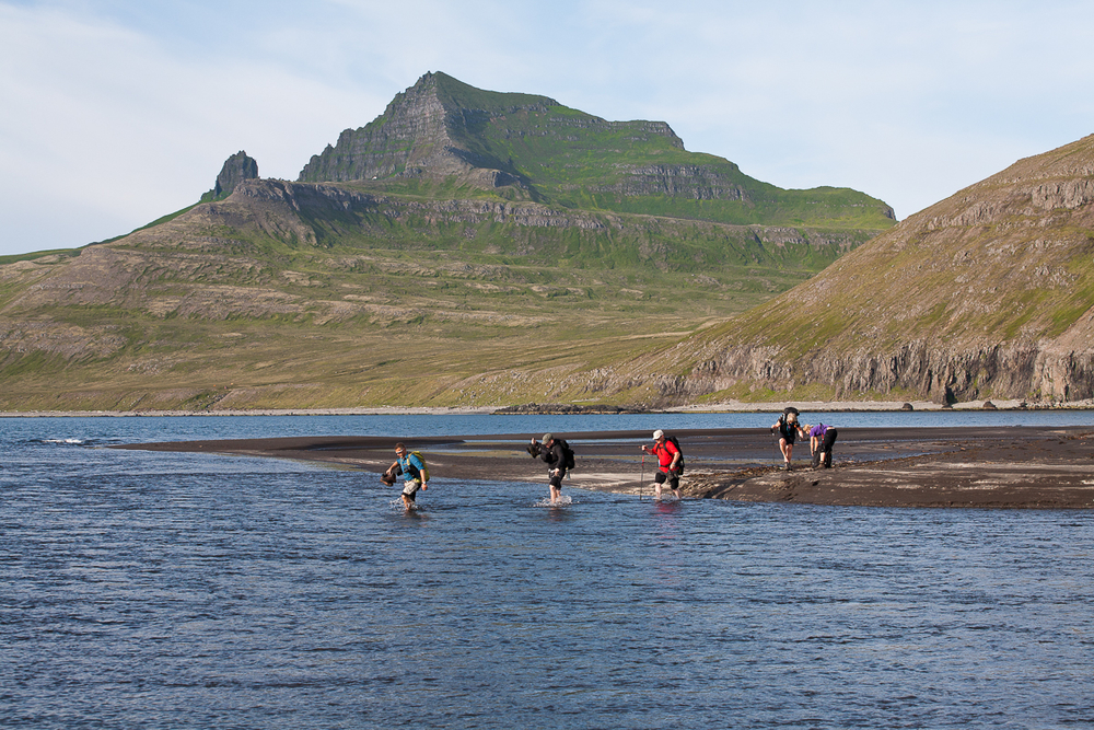 People On A Hike Going Through Water In Hornstrandir in Iceland