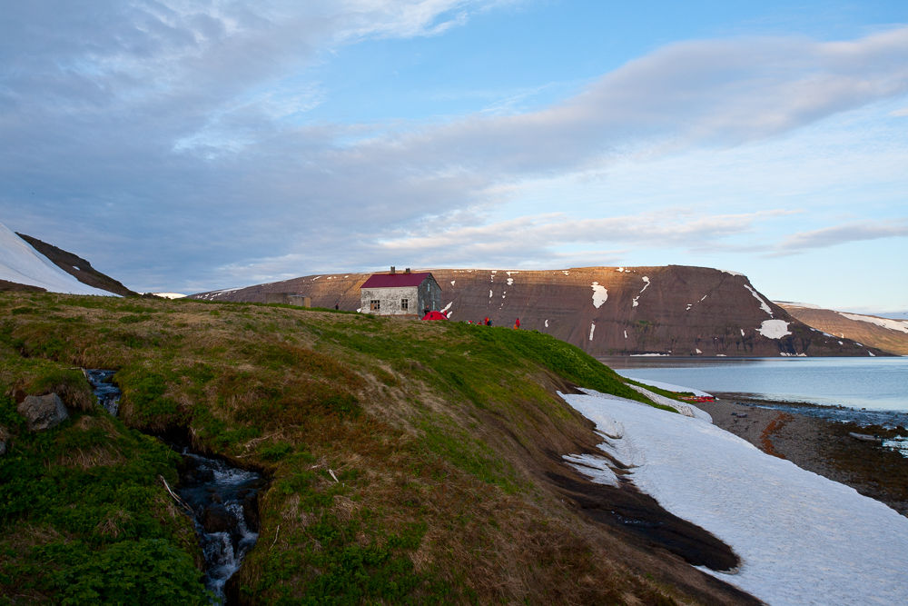 House With A Red Roof On A Hill With Mountains In The Background in Iceland