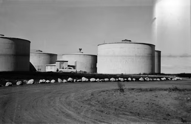 Original cylindrical water tanks on Öskjuhlíð hill in Reykjavík, with a vintage car parked between them.