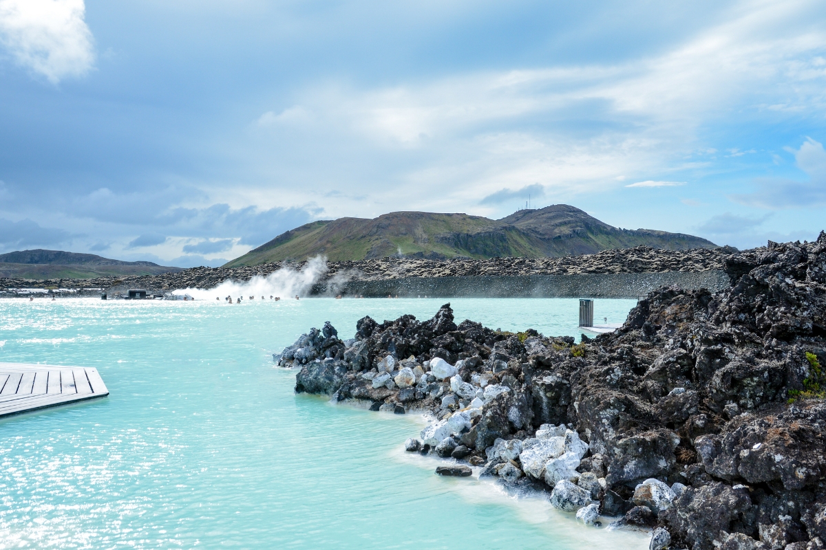 Aerial view of the Blue Lagoon's milky-blue geothermal water surrounded by black lava in Iceland.
