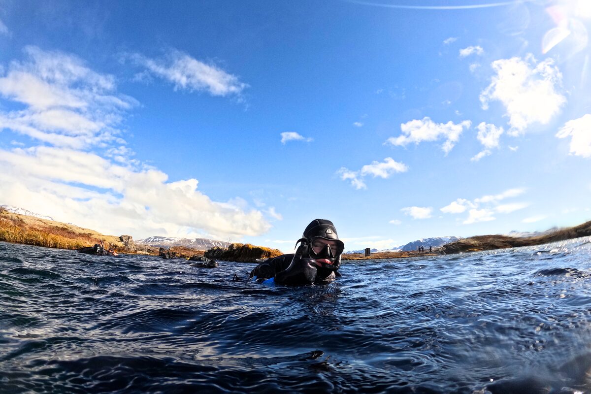 Arctic Adventures writer Justyna Zajkovska snorkeling at Silfra Fissure in a dry suit and hood.
