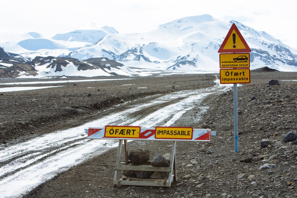 Closed road sign on the Icelandic highland route during winter storm conditions.