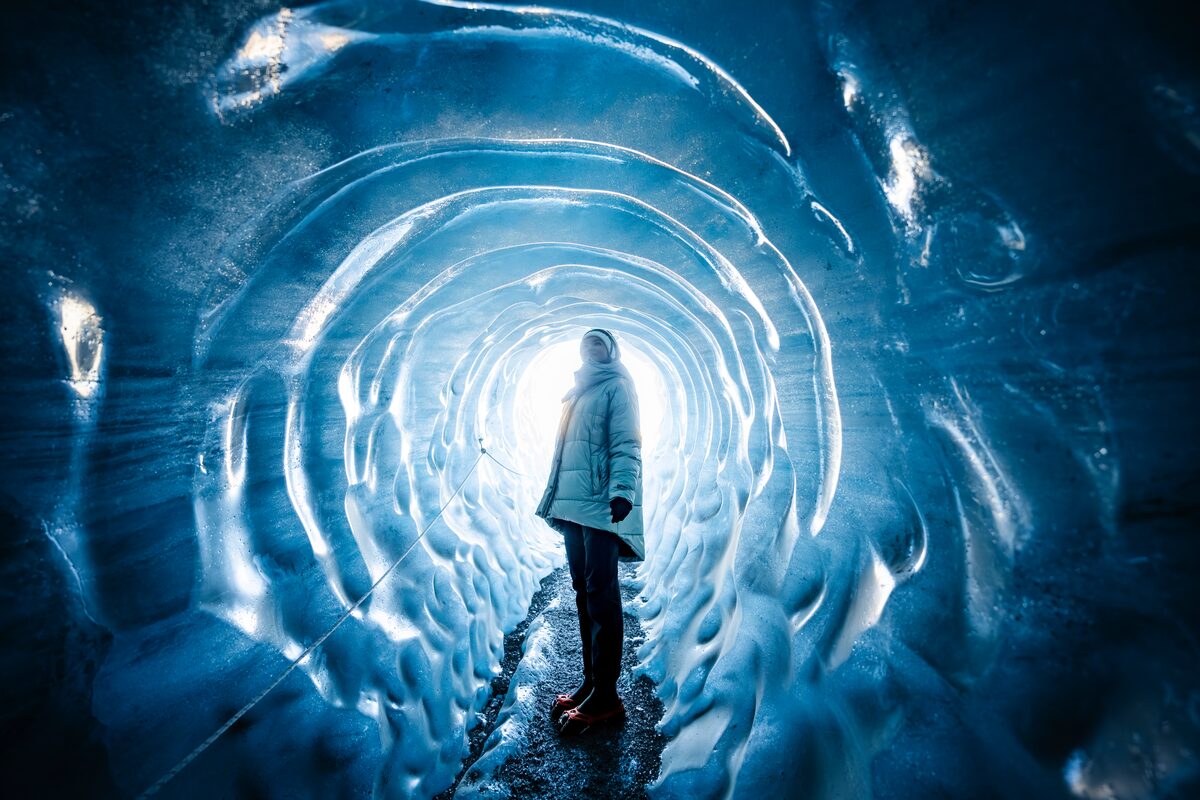 A woman standing inside a blue Katla ice cave under Mýrdalsjökull glacier, January 2026.