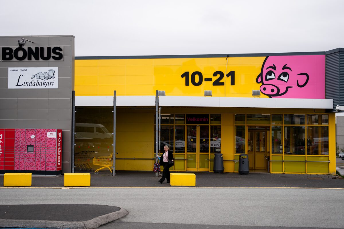 Bónus supermarket storefront with its pink pig logo and a person walking past, in Iceland.