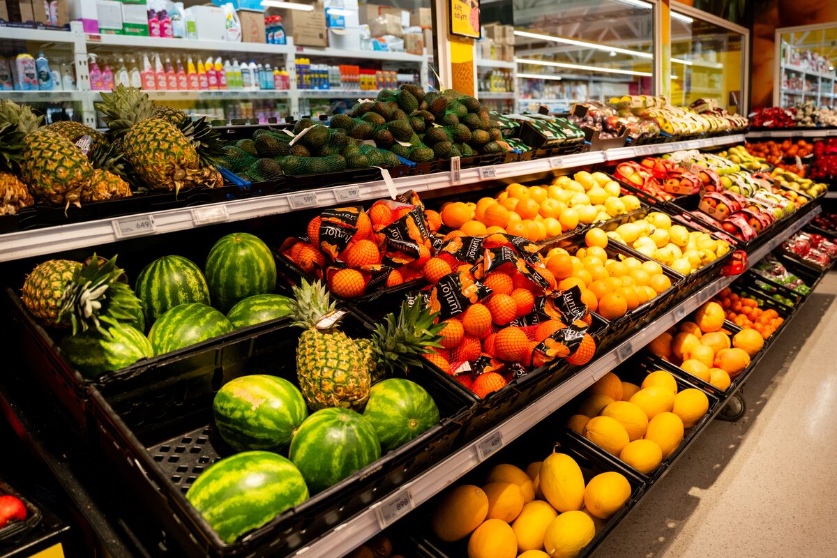 Produce display of watermelons, pineapples, oranges and apples at a supermarket in Iceland.