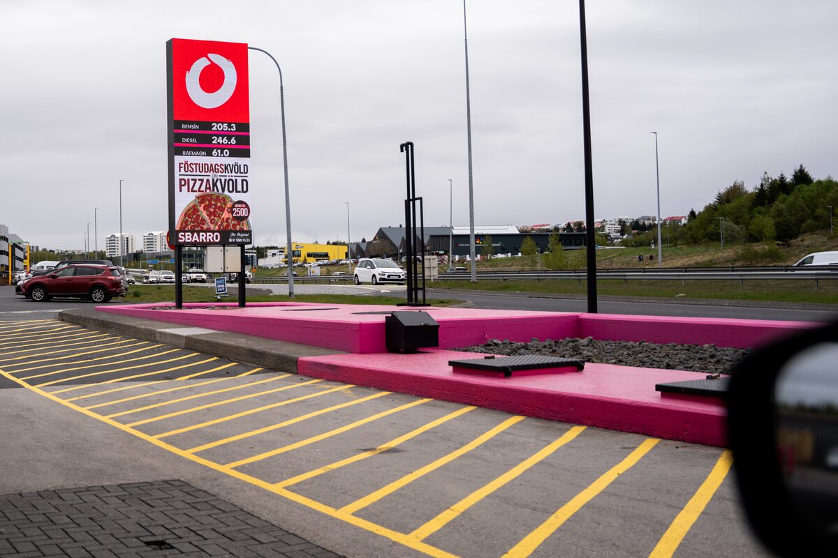 Fuel station price sign showing petrol and diesel rates per liter at a forecourt in Iceland.