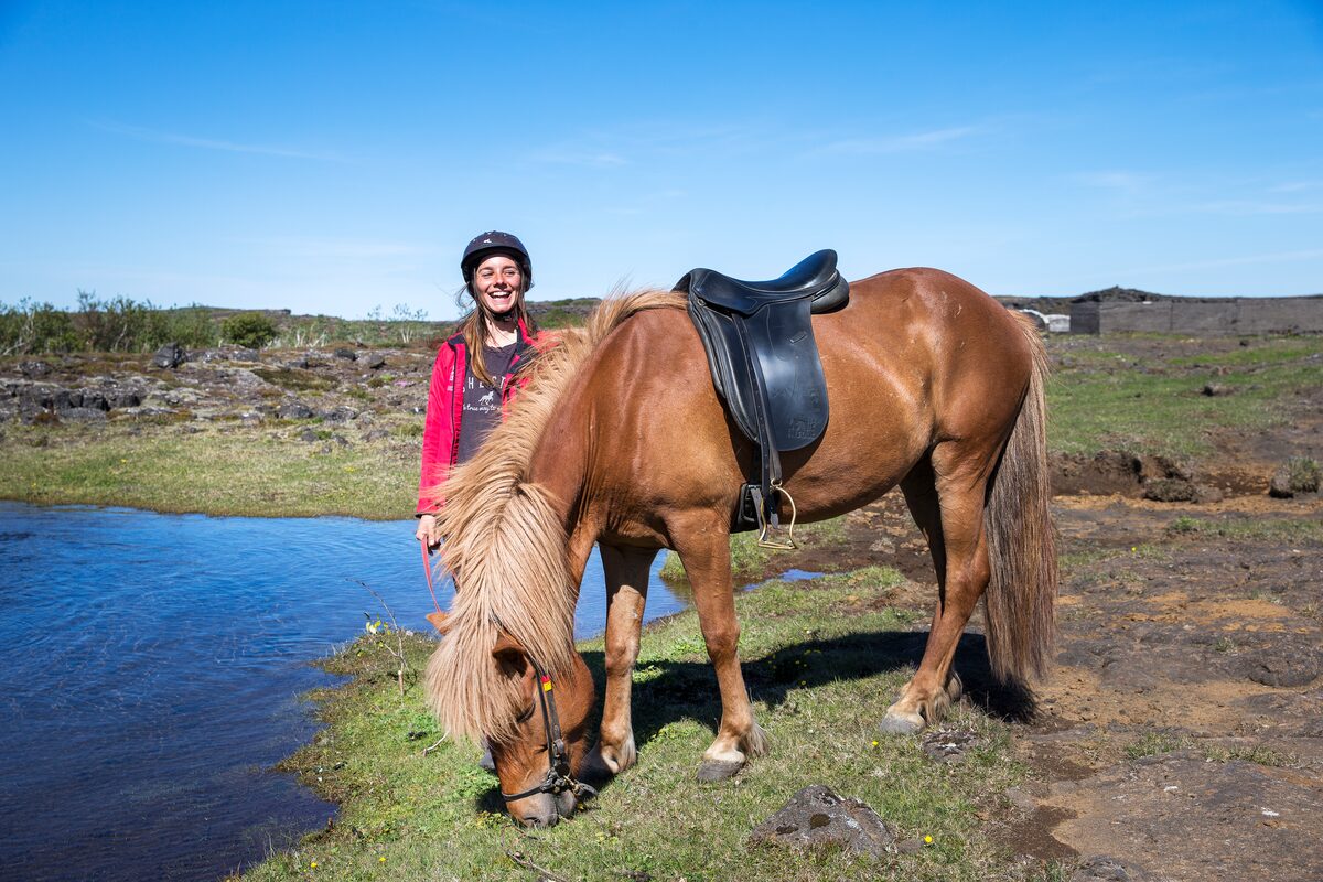 Girl Standing Next To A Horse Smilling in Iceland