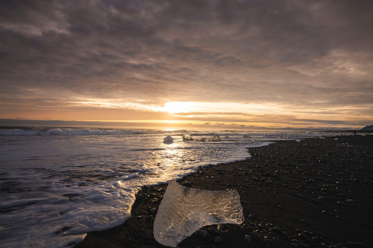 Glacier ice glowing on black sand at sunrise, Diamond Beach.