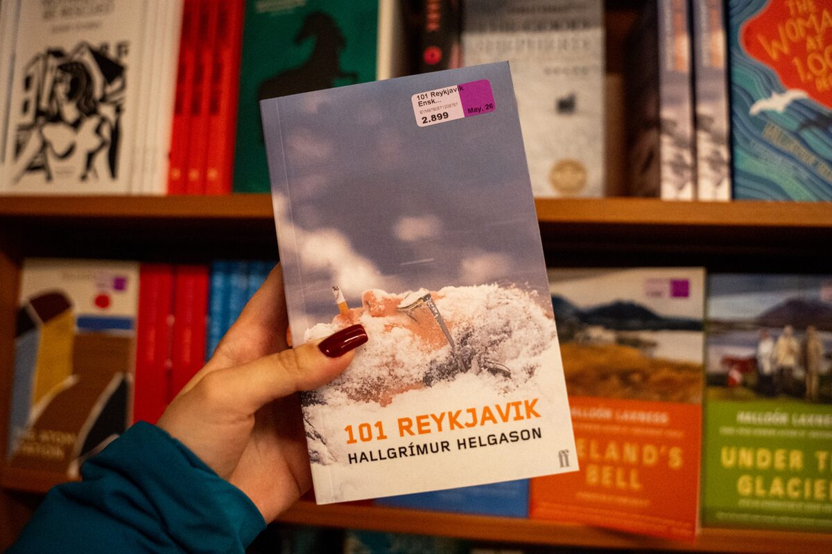 Hand holding the book 101 Reykjavík by Hallgrímur Helgason in a bookstore.