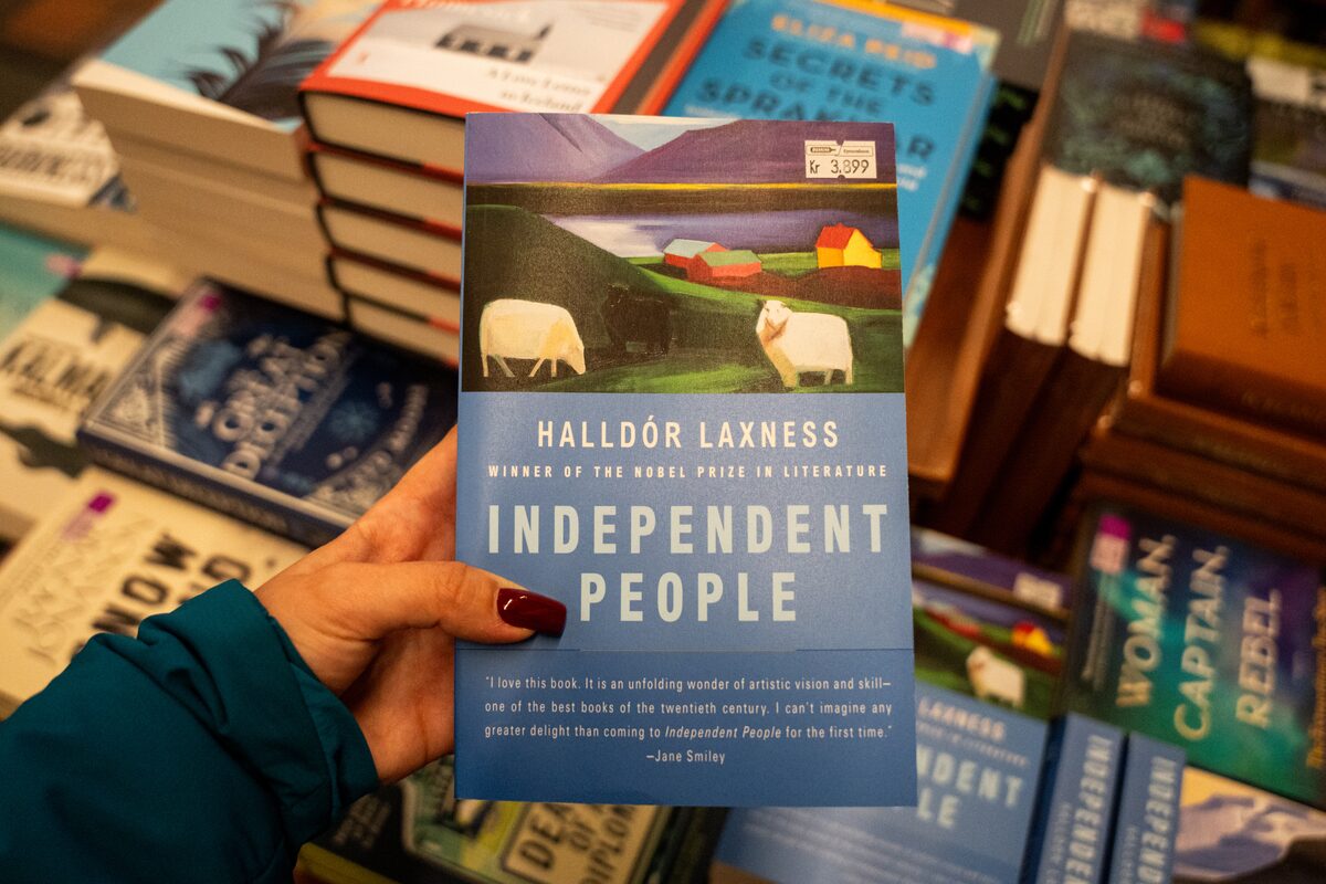 Person holds Halldór Laxness's novel Independent People above a bookstore display.