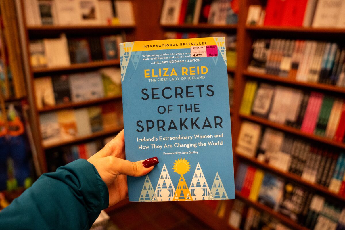 Hand holding the book Secrets of the Sprakkar by Eliza Reid in a bookstore.