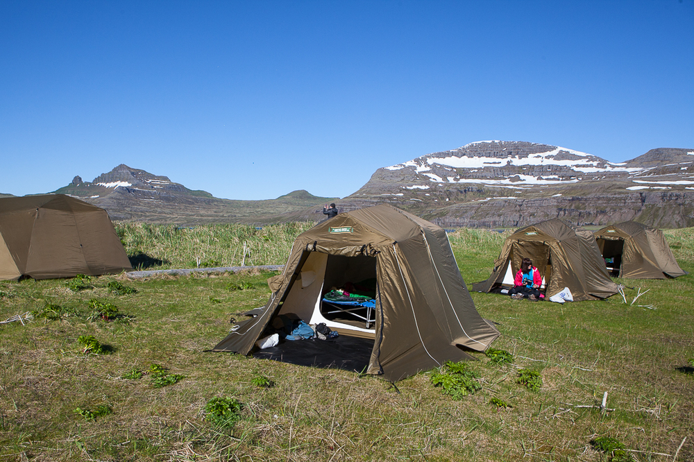 Built Brown Tents With A Mountain In The Background in Iceland