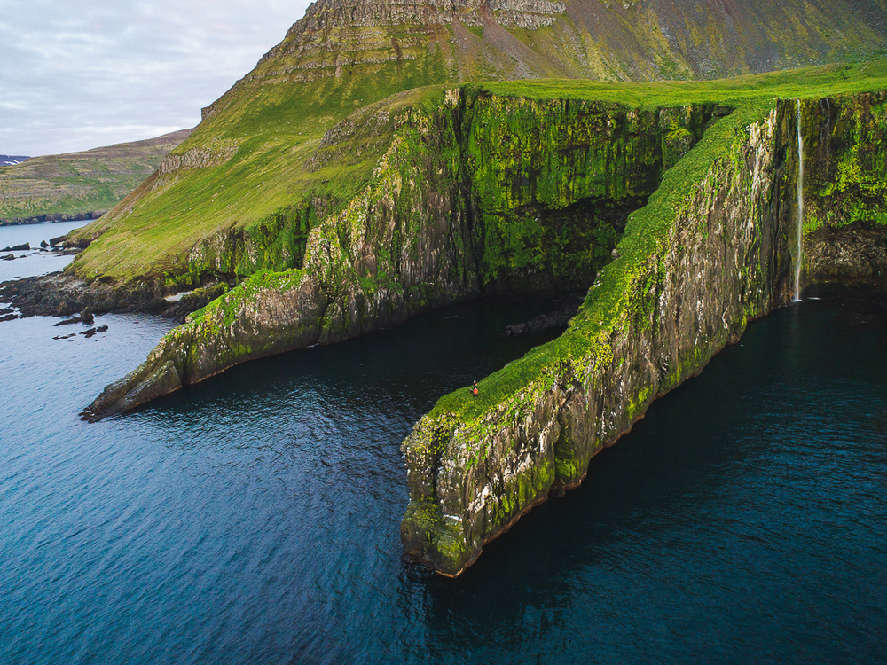 Green Cliff With Water Beneath Them in Iceland