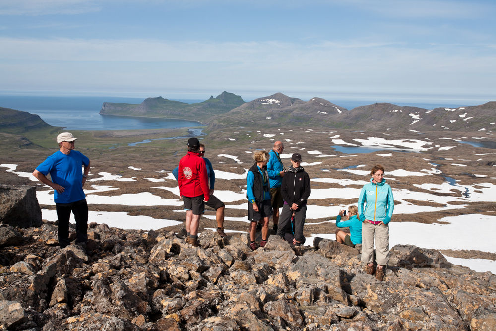 Group Of Hikers Standing On Top Of A Rocky Hill in Iceland