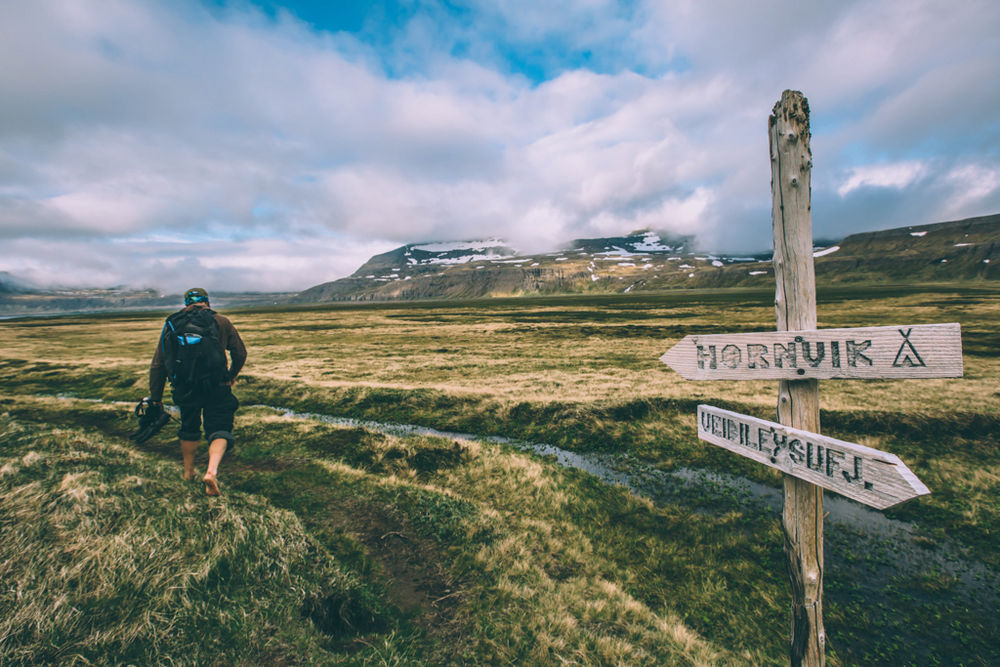Hiker Near A Sign For Hiking Trails in Iceland