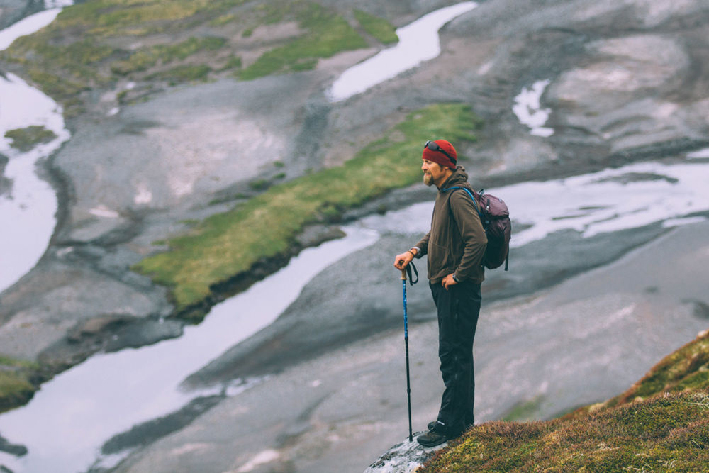 Hiker With A Walking Stick Standing On A Mountain in Iceland
