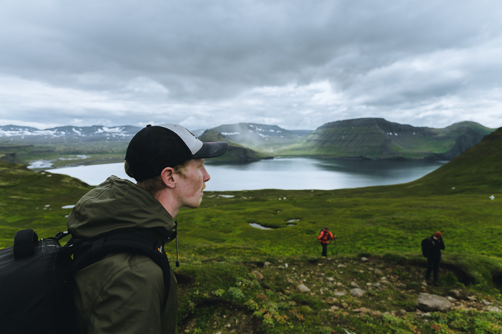 Man Photographed From A Profile With Green Fields, Mountains And Water In The Background in Iceland